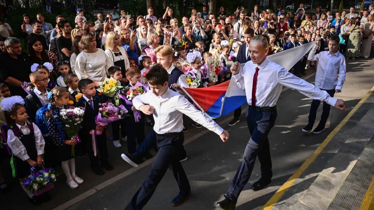 Школьники идут флагом России на «первом звонке» в Москве, 1 сентября 2023 года. Фото: Юрий Кадобнов / AFP / Scanpix / LETA